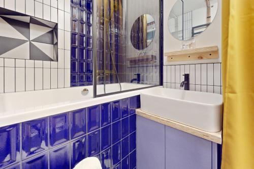 a bathroom with blue and white tiled walls and a sink at Stunning 1 BD apartment for 3 people in Hackney with Japanese-style bath in London
