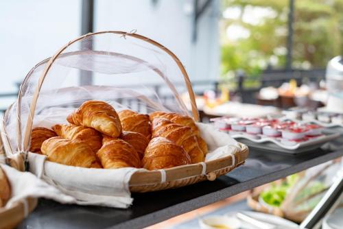 a basket of croissants and other pastries on a table at LuangPrabang Center Hotel in Luang Prabang
