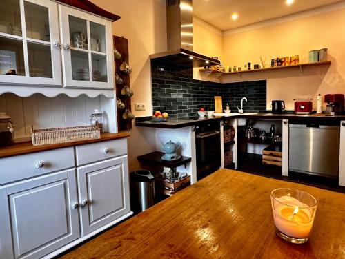 a kitchen with a wooden table with a drink on it at Gemütliche Ferienwohnung in Uelzen mit eigenem Garten in Uelzen