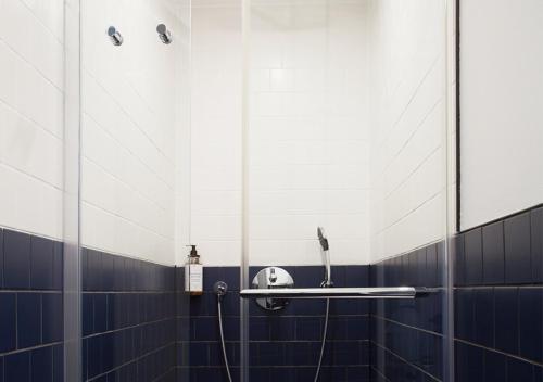 a bathroom with blue and white tiled walls and a shelf at Hôtel La Nouvelle République & Hammam in Paris