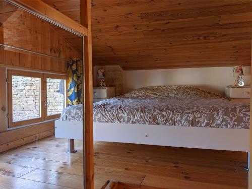 ein Schlafzimmer mit einem Bett in einer Holzhütte in der Unterkunft The Bean Barn in Arçais