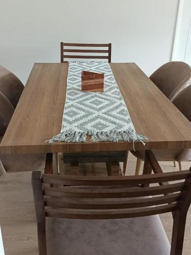 Departamento familiar Villarrica في فيلاريكا: طاولة خشبية عليها كراسي وبطانية