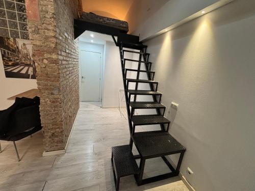 a staircase in a room with a chair and a wall at Estudio para parejas in Barcelona