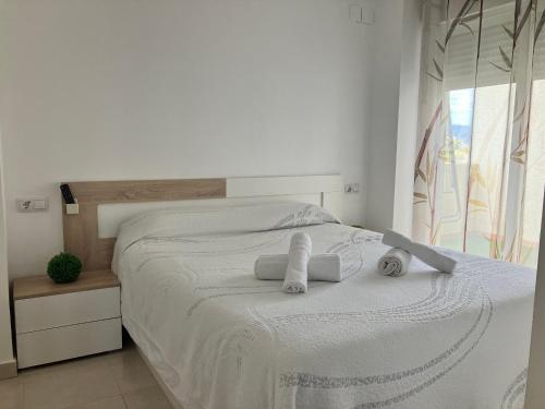 a white bedroom with a bed with towels on it at APARTAMENTO PINAPLAYA in Grao de Castellón