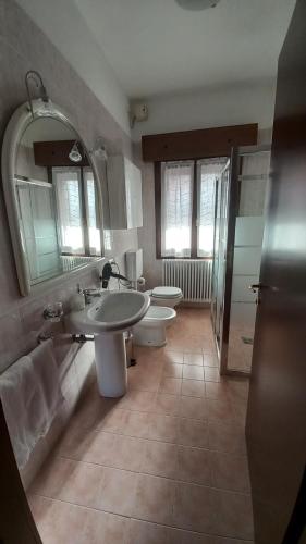 a bathroom with two toilets and a sink and a mirror at RB Bed & Breakfast in Gaiba