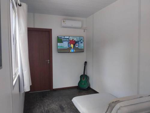 Zimmer mit einem Wand-TV in der Unterkunft Casa contenedor super cómoda in La Floresta