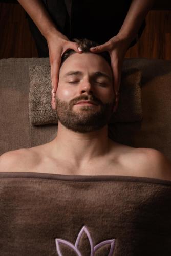 a man is getting his headived with his hands at Crowne Plaza - Belfast by IHG in Belfast