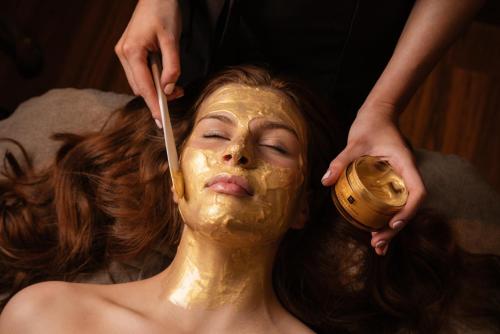 Crowne Plaza - Belfast, an IHG Hotel في بلفاست: امرأة ترتدي قناعا ذهبيا على وجهها