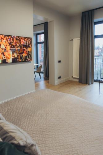 a bedroom with a bed with a picture on the wall at Apartments Vitenberg in Cēsis