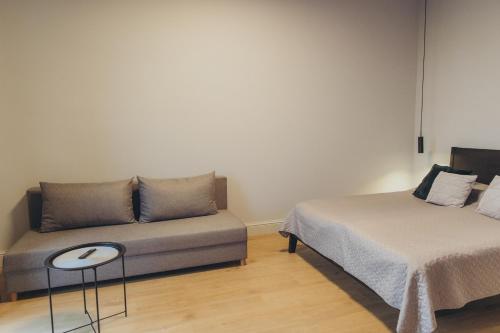 a living room with a couch and a bed at Apartments Vitenberg in Cēsis