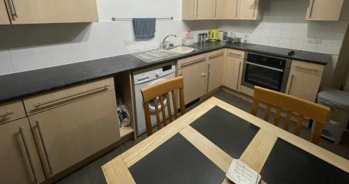 a kitchen with a table and two chairs in it at Business & Leisure City Centre 2 Bed En-suite Apartment with free parking and Netflix in Coventry