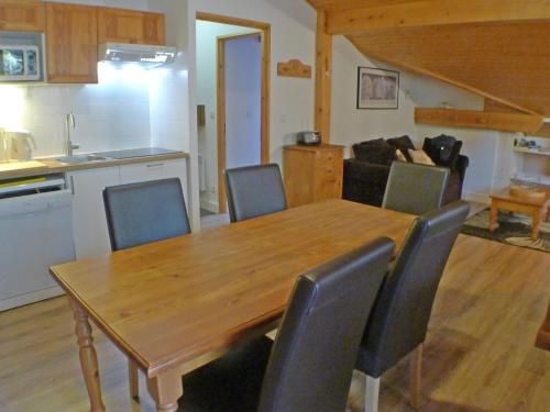 une cuisine et une salle à manger avec une table et des chaises en bois dans l'établissement Appartement T4 pour 8 Pers. avec Piscines et Parking - Résidence Le Grand Tétras à Samoëns - FR-1-629-131, à Samoëns
