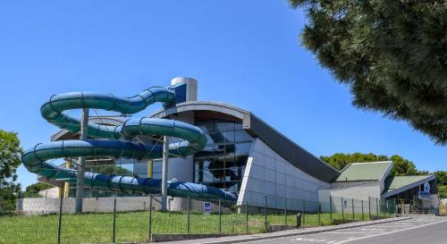 un toboggan devant un bâtiment dans l'établissement Perpignan Parc des sports-15min de la mer, à Perpignan
