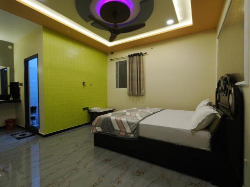- une chambre avec un lit et un plafond avec une lumière violette dans l'établissement Coconut Homestay Hampi, à Hampi