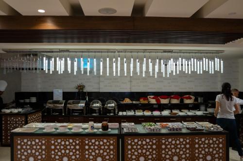 a woman standing in front of a buffet line with food at My Hotel by Trend in Aqaba