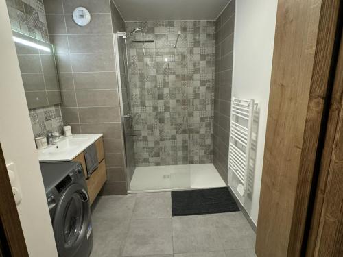 une salle de bain avec douche et machine à laver dans l'établissement Les Gets: Appartement cosy, garage privé, Wi-Fi, linge inclus - FR-1-671-256, aux Gets