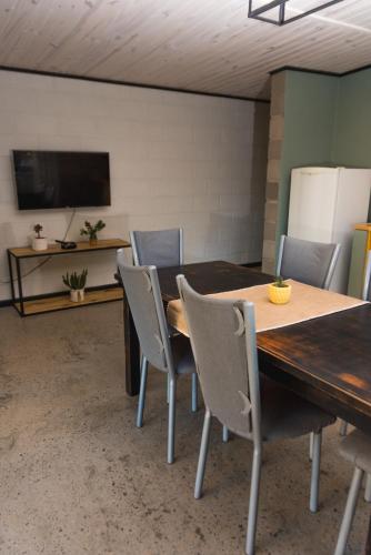 comedor con mesa de madera y sillas en ALMA Posada en Almafuerte