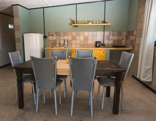 una mesa y sillas en una habitación con cocina en ALMA Posada en Almafuerte