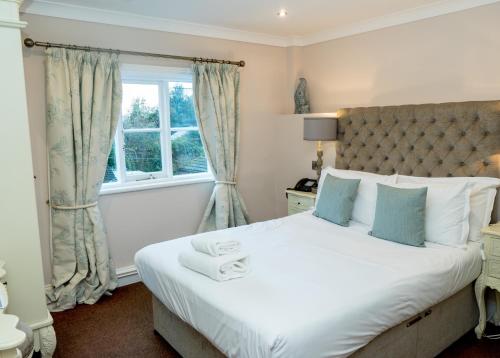 a bedroom with a large bed and a window at The Oak Kelsall in Kelsall