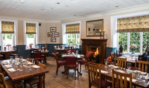 a restaurant with tables and chairs and a fireplace at The Oak Kelsall in Kelsall