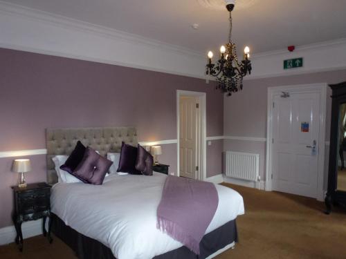 a bedroom with a large bed with purple pillows at The Oak Kelsall in Kelsall