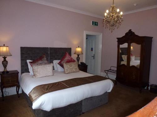 a bedroom with a large bed and a chandelier at The Oak Kelsall in Kelsall