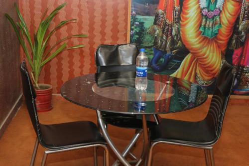 uma mesa e duas cadeiras com uma garrafa de água em hotel new agarwal em Jhunjhunūn