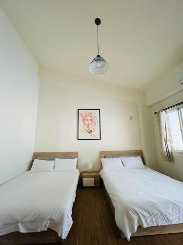 2 Betten in einem Zimmer mit weißer Bettwäsche in der Unterkunft Vuluq in Shoufeng