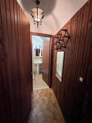 a hallway of a bathroom with a sink and a chandelier at Appartamento "La Lanterna" - a 10 minuti dal mare in Badalucco
