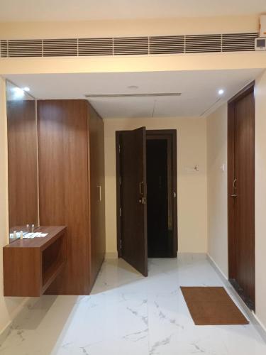 ein Badezimmer mit Holzschränken, einem Waschbecken und einer Tür in der Unterkunft SAS SQUARE in Tiruchchirāppalli