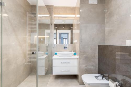 bagno con lavandino e doccia in vetro di Vistula River Premium Apartment a Cracovia