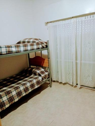 Zimmer mit 2 Etagenbetten und einem Fenster in der Unterkunft STELLA MARIS in Las Grutas