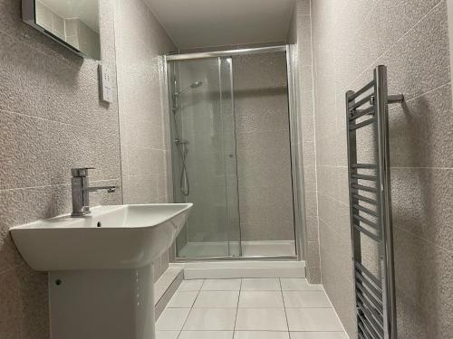 a bathroom with a sink and a shower at Two Bedroom Duplex Apartment The Priory in St Ives