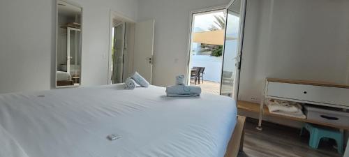 1 dormitorio con 1 cama blanca grande y espejo en Sabbia Suite Casa Jalofa en El Golfo