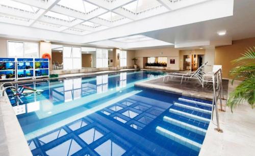 una grande piscina con acqua blu in un edificio di FLAT EM ALPHAVILLE HOTEL CONFORT MELHOR LOCALIZAÇÃo a Barueri