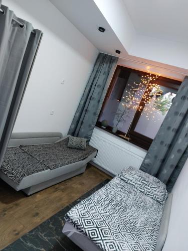 a small room with two beds and a window at Głogów przy Grodzkiej in Głogów