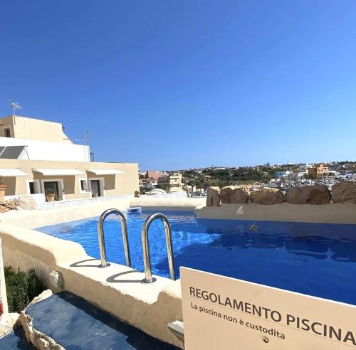 una piscina con un cartello di fronte al resort di Hotel Medusa a Lampedusa