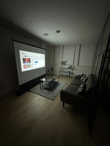 a living room with a couch and a projection screen at Stylish 1 Bedroom Apartment in Purley, Croydon in London