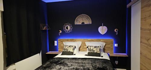 - une chambre bleue avec un lit et 2 oreillers dans l'établissement Le Clos Maldier - Gîte Les Ecureuils, à Laon