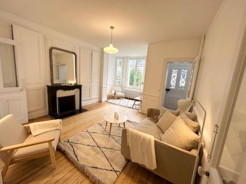 un salon avec un canapé et un miroir dans l'établissement Villa Jean- plein centre Etretat, à Étretat