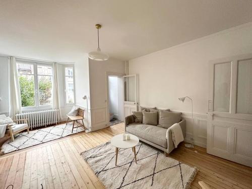 un salon blanc avec un canapé et une table dans l'établissement Villa Jean- plein centre Etretat, à Étretat