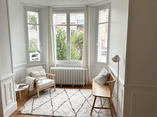 - un salon avec une chaise et 2 fenêtres dans l'établissement Villa Jean- plein centre Etretat, à Étretat