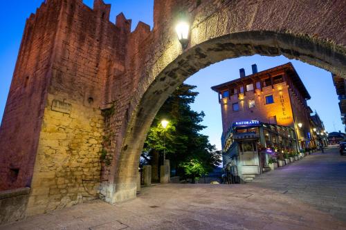 ein Torbogen über eine Straße in einer Stadt nachts in der Unterkunft Hotel Cesare in San Marino