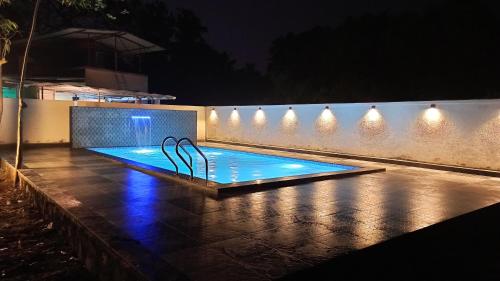 a swimming pool at night with lights on a wall at Kamal Homes in Kīhīm