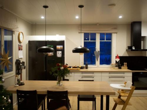 a kitchen with a wooden table and a refrigerator at Arctic Lakeside Home in Kemijärvi