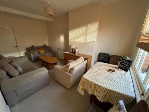 a living room with a couch and a table at Two bed flat in popular York Rd in Birmingham