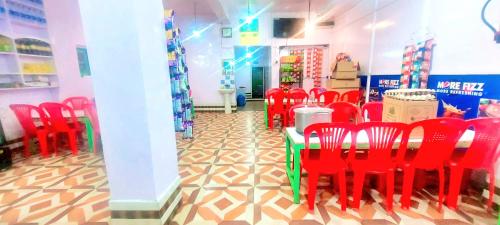 una stanza con sedie rosse e un tavolo in un negozio di Indra Guest House a Anantnāg