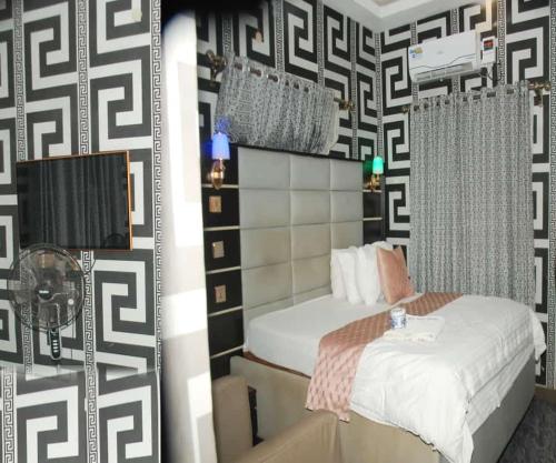 sypialnia z łóżkiem i czarno-białą ścianą w obiekcie Rizz Park Hotel & Event Center w mieście Nnewi