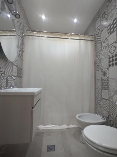 a white bathroom with a toilet and a sink at Entre fincas alojamiento rural in San Rafael