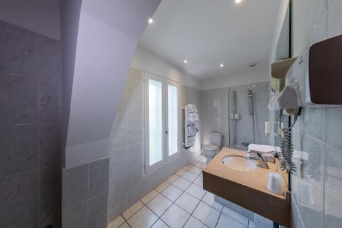 uma casa de banho com um lavatório e um WC em Noemys Neris Montlucon - hotel restaurant em Néris-les-Bains